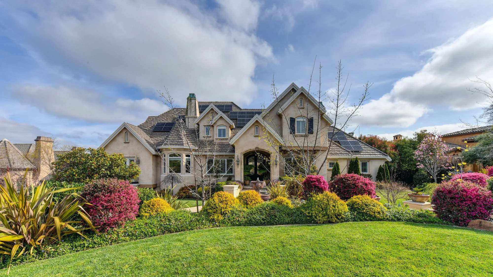 A landscaped garden with a lush green lawn in front of a home